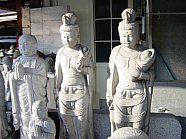 Modern stone statue of Kannon Bosatsu holding a baby