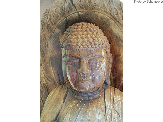 Wood carving of Buddha showing a second face emerging from main head. Probably suggests the 'Buddha hidden within each of us' or our true nature. Statue found in small shop outside Donghaksa Temple.